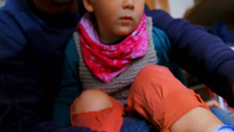 padre ayudando a su hijo a usar calcetines en el dormitorio en casa 4k