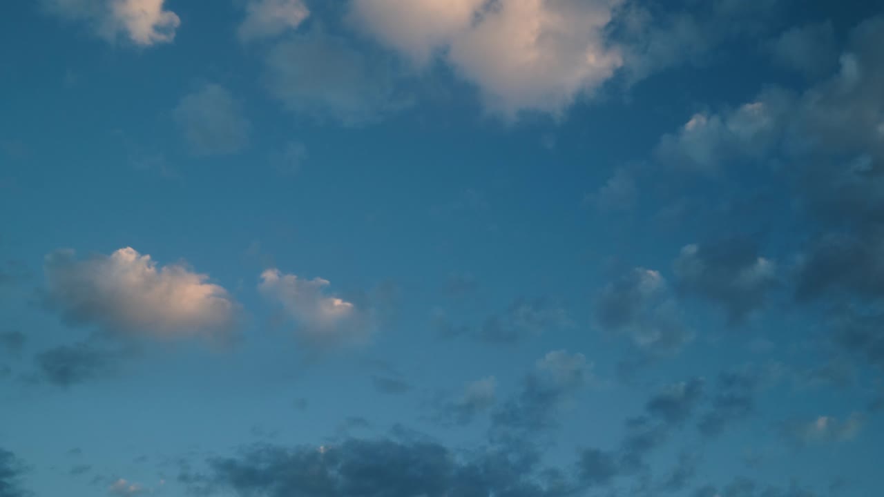Clouds floating across the sky in a calming timelapse sequence with blue tones