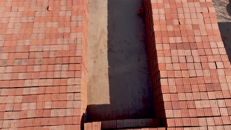 fábrica de construcción con pilas de ladrillos apilados y cargados en camiones para el transporte