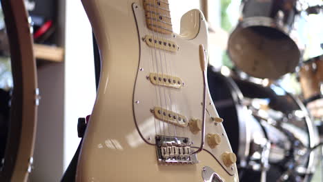 a vintage electric guitar musical instrument next to a drum set in a rock and roll garage band stage