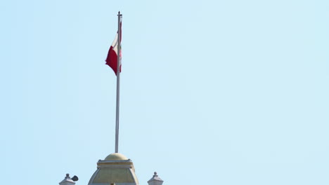 closeup footage of peru flag waving on municipal palace at chiclayo, peru during daytime.