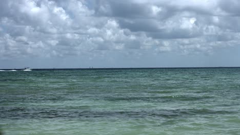 White-boat-traveling-the-ocean,-in-the-distance