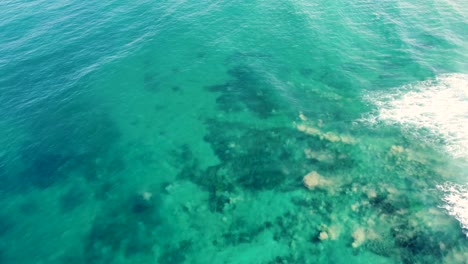 Drone-aerial-shot-of-crystal-clear-water-sand-banks-Pacific-Ocean-coastline-Shelly-Beach-Central-Coast-NSW-Australia-4K