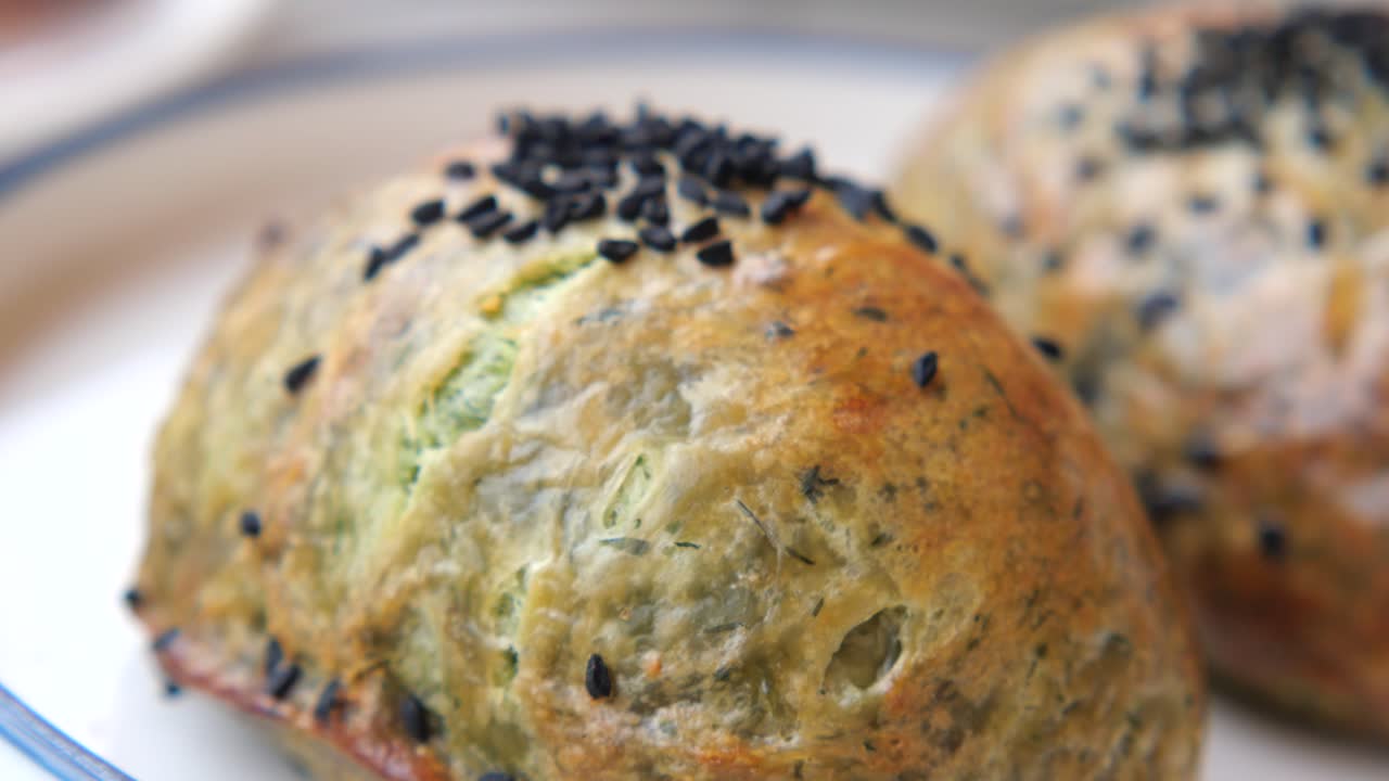 Close-up of a Golden Brown Savory Pastry Topped with Black Seeds