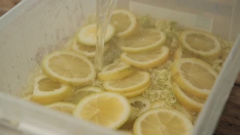 making a elderflower syrup by pouring hot water over ingredients