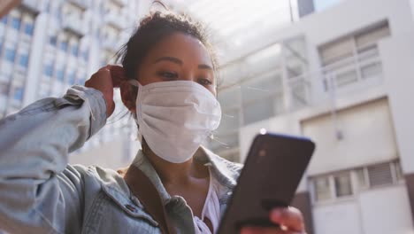 mixed race woman wearing medical coronavirus mask on the street