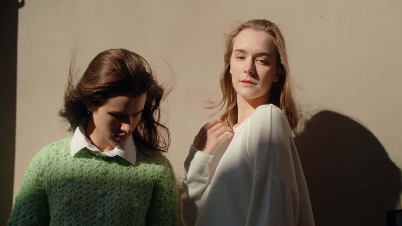 Two young women posing outdoors in sunlight