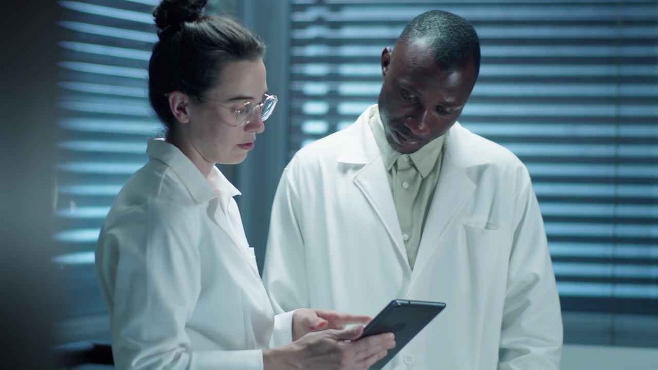 Scienziati di laboratorio che usano un tablet e discutono