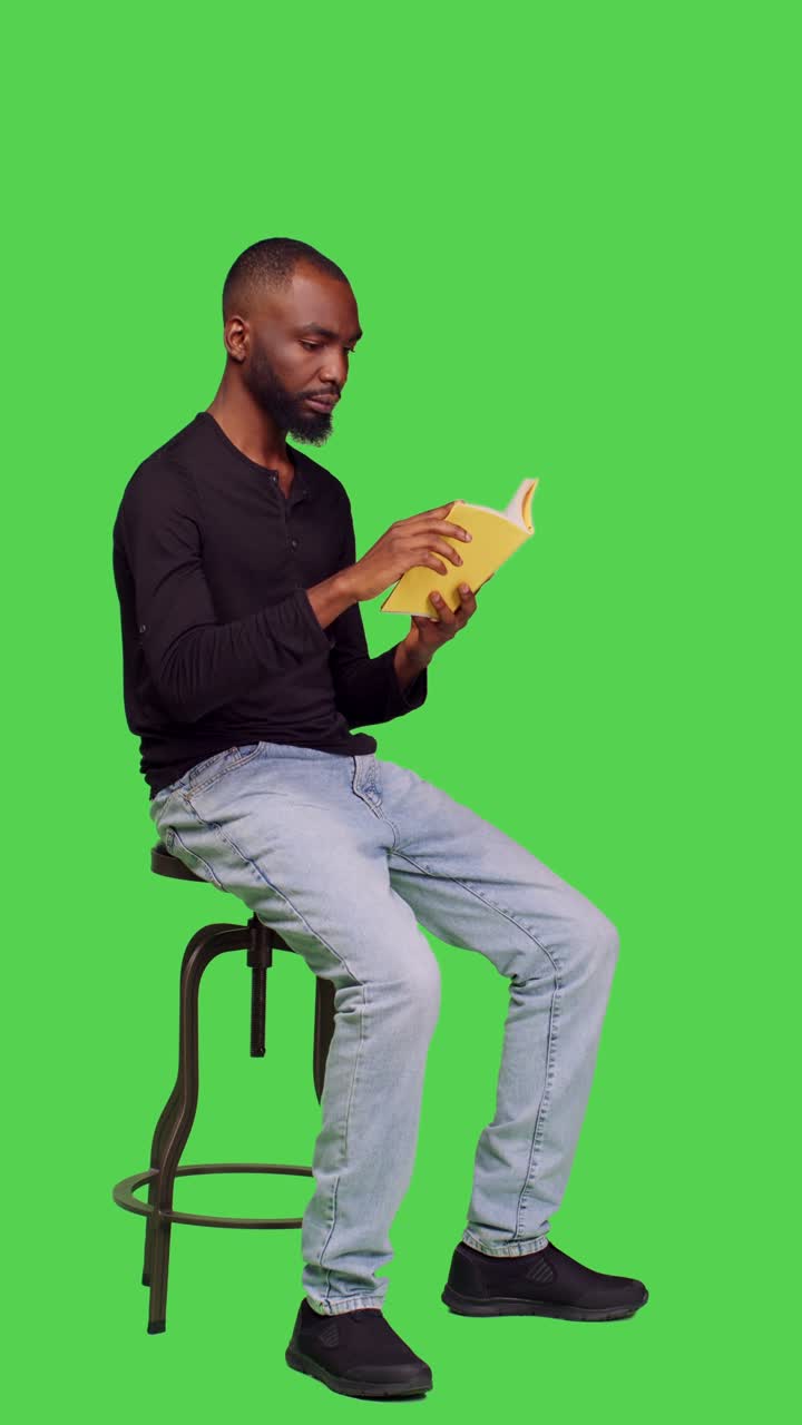 Vertical video: Side view of positive person holding story book on camera