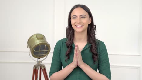 mujer india diciendo namaste y saludos