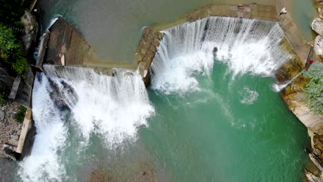 Aerial-view-large-river-turning-into-a-huge-waterfall-in-the-mountains