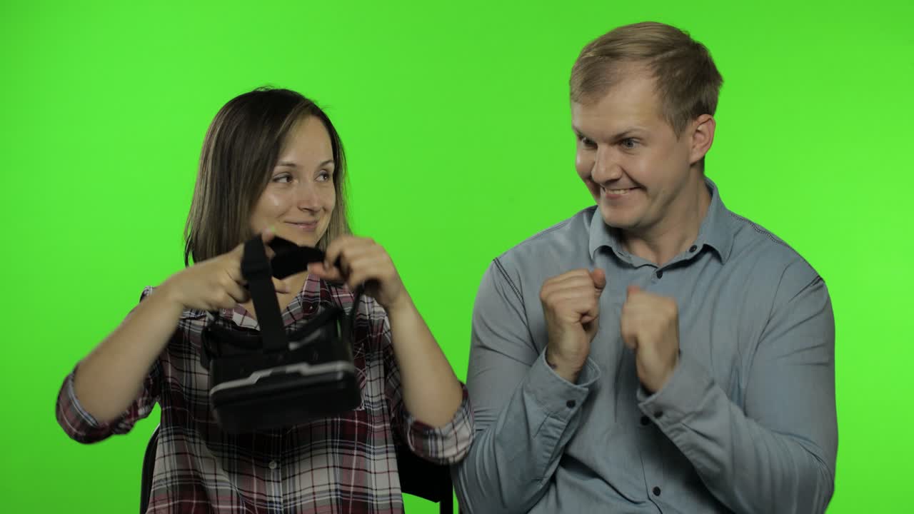 Man and woman using VR headset helmet to play game. Watching virtual reality 3D video. Chroma key