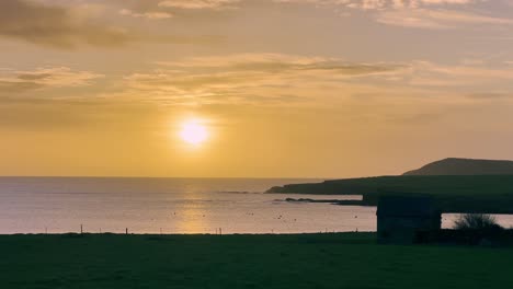 early morning with winter sunrise over coastal road and village in west cork, ireland