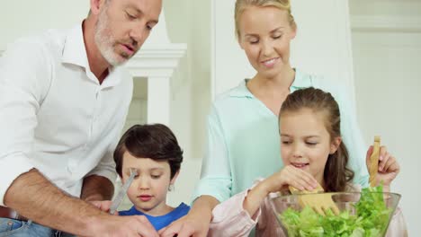 parents assisting kids in preparing salad