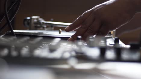 High Definition close up shot of vinyl spinning on turn table and then focus pulling to DJ's hand by spinning vinyl