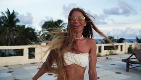 Hermosa-Mujer-Con-Bikini-Blanco-Y-Gafas-De-Sol-Girando-Con-El-Pelo-Largo