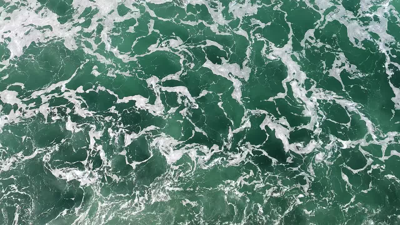 Aerial Top-Down View of Green Ocean Water with White Foam