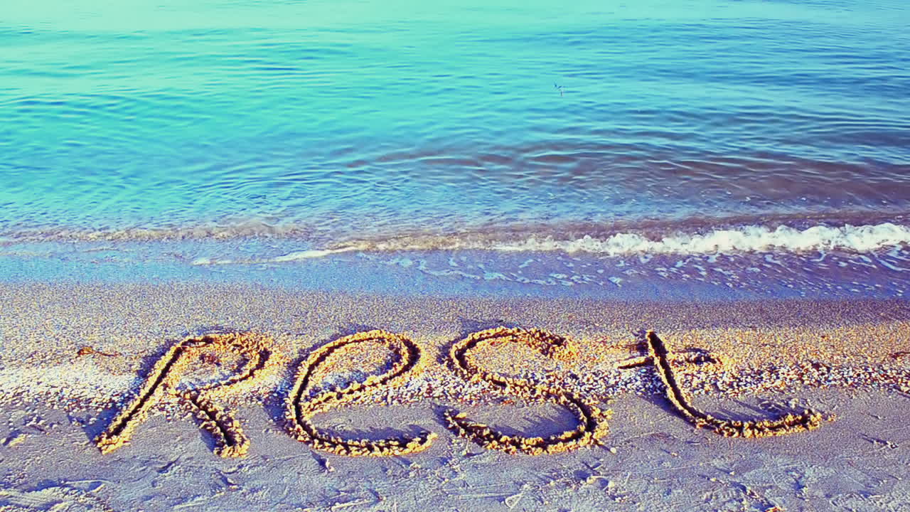 Inscription rest on sand, the beach. Inscription on sand, the beach