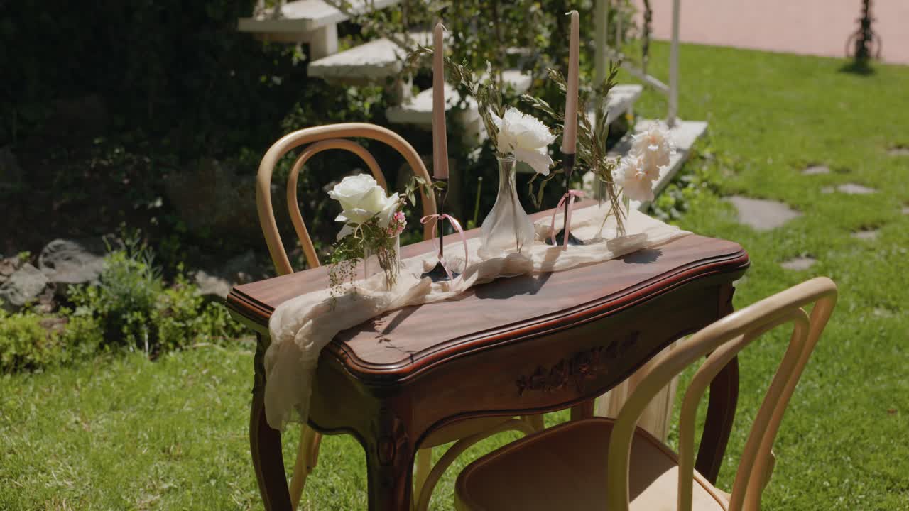 Classic Table Setting Of Candles With Glass Flower Vases For Wedding Ceremony. Zoom In Shot