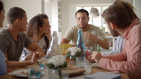 Young-adult-friends-talking-at-a-table-over-lunch,-close-up