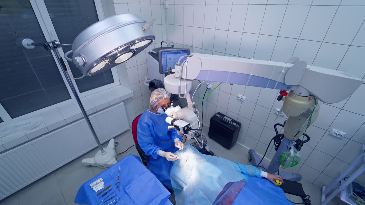 Ophthalmology surgery for eyes. Surgeon looking into the microscope at the eye of patient at the operating room