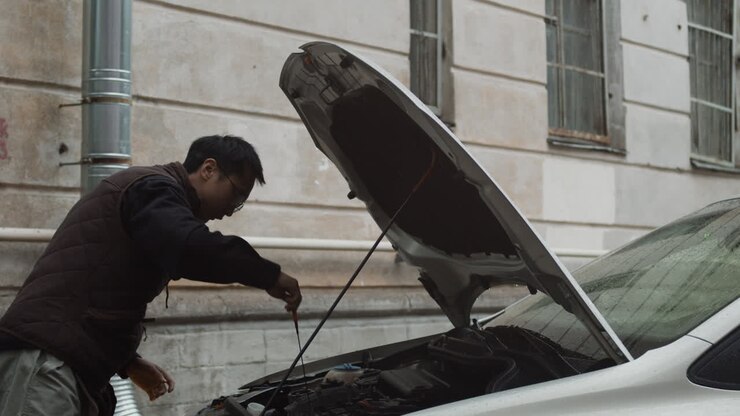 Uomo che controlla il motore dell'auto