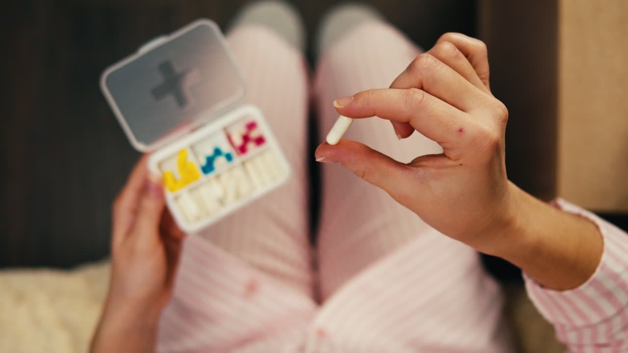 침대에서 약을 복용하는 여성