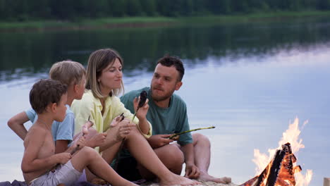 family eating sausages on the beach