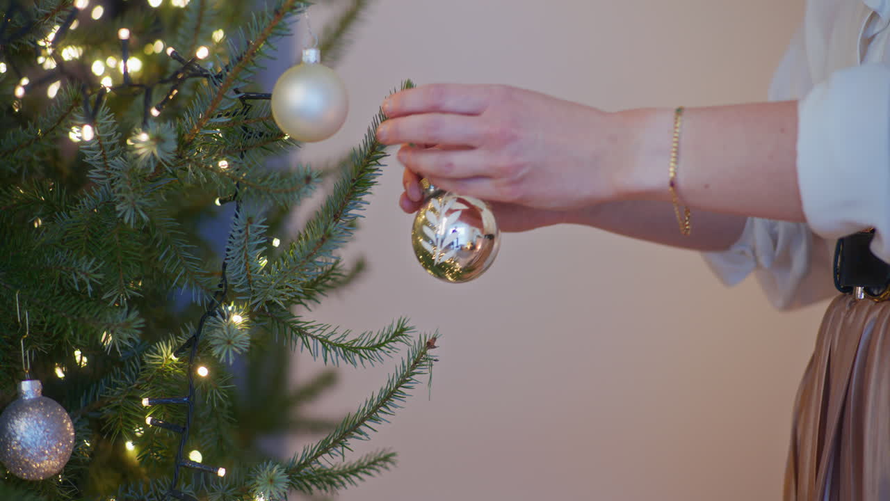 Mujer colocando adorno de Navidad en el árbol y adornándolo