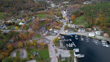 ciudad de sunapee, new hampshire, ee.uu., vista aérea de la orilla del lago, puerto y colorido follaje otoñal, tiro con drones