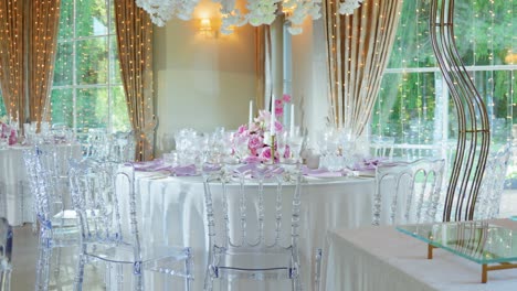 decorations and tables with pink gorgeous flowers in a wedding venue