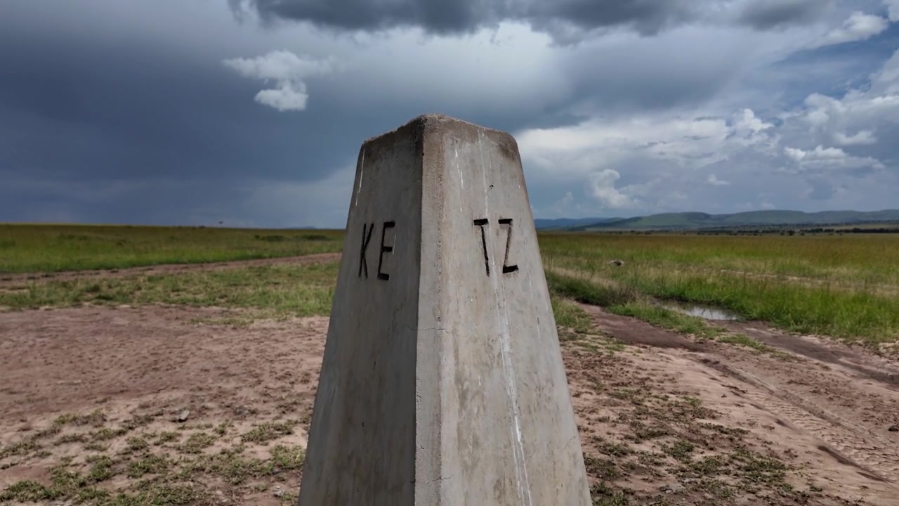 Betonový hraniční kámen mezi Keňou a Tanzanií v národní rezervaci Masai Mara.