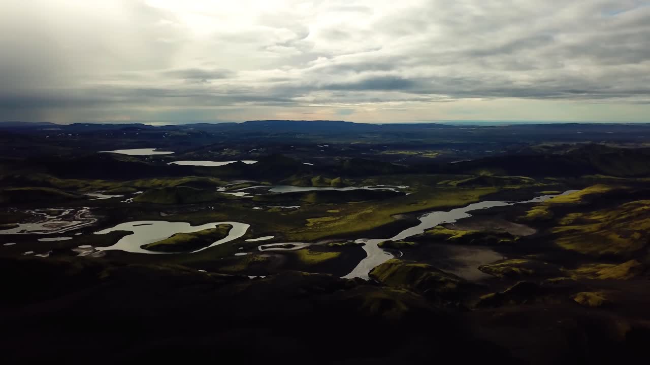 vista aérea del paisaje de las tierras altas de islandia, colinas y montañas oscuras, ríos y lagos, en un día nublado