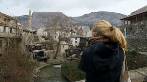 Clip-De-Vista-Posterior-De-Una-Mujer-Rubia-Mirando-Las-Vistas-Del-Casco-Antiguo-De-Mostar-Mientras-Estaba-De-Pie-En-Un-Puente-Alrededor-De-Noviembre-De-2018