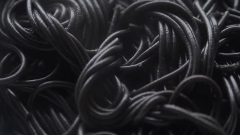 Close-up-of-hot-steaming-black-spaghetti-in-a-white-bowl