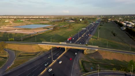 cars, trucks, and buses are moving along the road and under the bridge close to peaje hudson toll, buenos aires, argentina