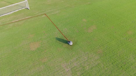 a robot autonomously paints precise lines on a soccer field under bright daylight, enhancing field markings efficiently