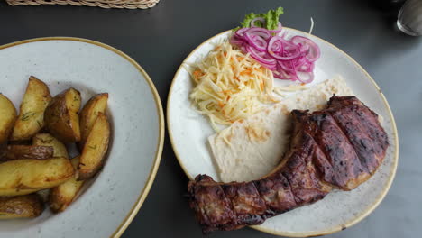 Plates-Of-Potato-Wedges-And-Grilled-Chicken-With-Tortilla,-Coleslaw,-And-Pickled-Red-Onions