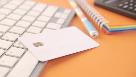 credit card on keyboard with office supplies