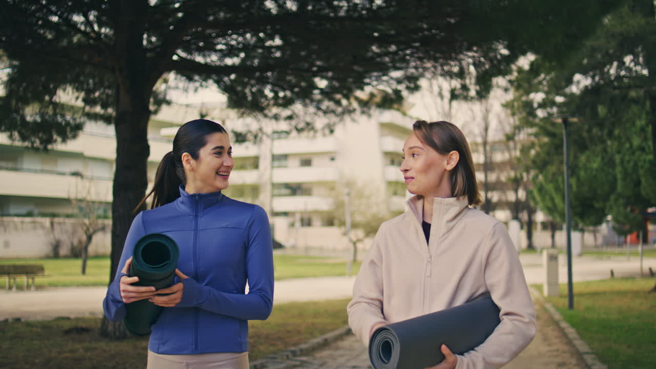 atletas alegres hablando felizmente caminando parque. yogini alegre hablando al aire libre