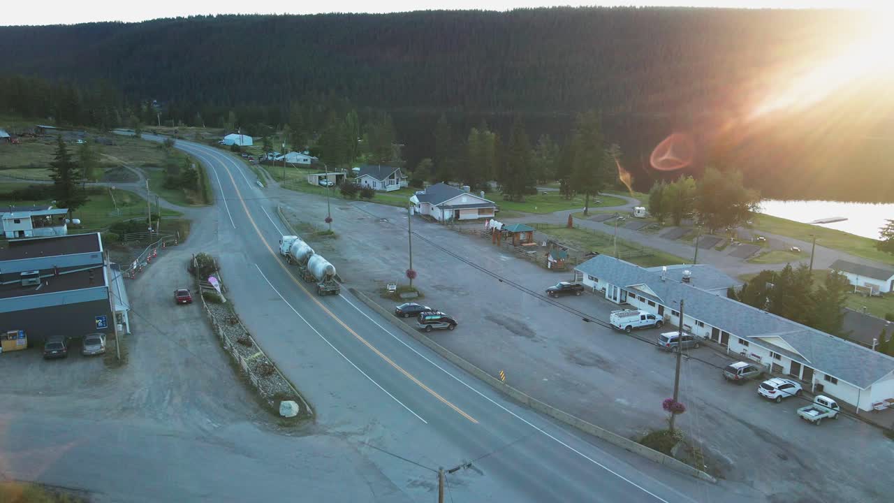 유조선 트럭은 캐나다 브리티시 컬럼비아에서 일몰 동안 mc 리즈 호수를 통과합니다.