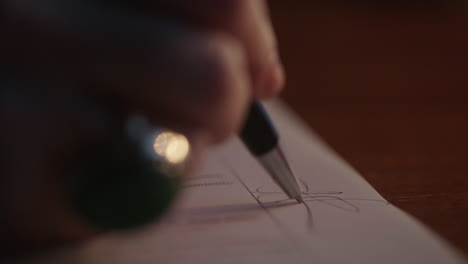 person writing on paper with pen