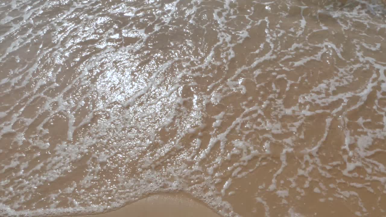 햇살 가득한 낮에 평화로운 바다에서 하얀 모래와 파도가 있는 해변