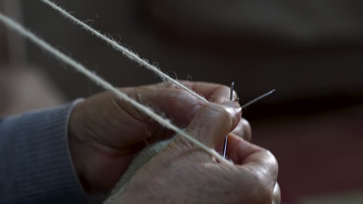Grandmother hands knitting with wool yarn and needles handmade knit socks, retirement grandma working