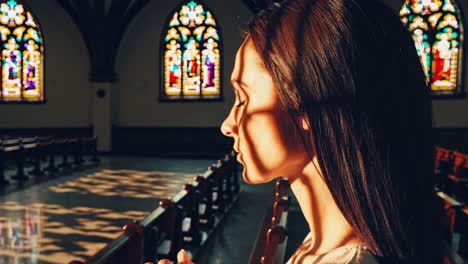 side profile of a woman praying in a church, bathed in stained glass light