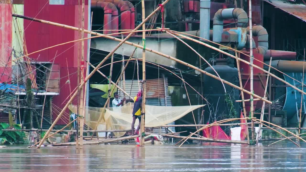 The Flood Overwhelmed the River, Disrupting Trap Net Fishing and Impacting a Nearby Industrial Factory and its Workers in Sylhet, Bangladesh, South Asia - Static Shot