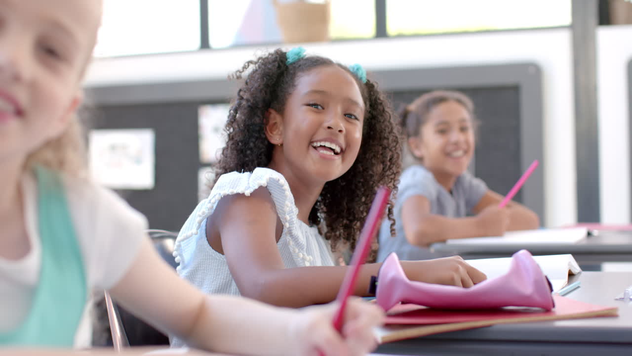Biracial and Caucasian girls enjoy a school classroom activity