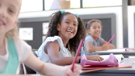 biracial and caucasian girls enjoy a school classroom activity