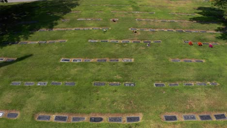 low aerial shot flying over gravestones and tilting up to a stone mausoleum at a mortuary in california