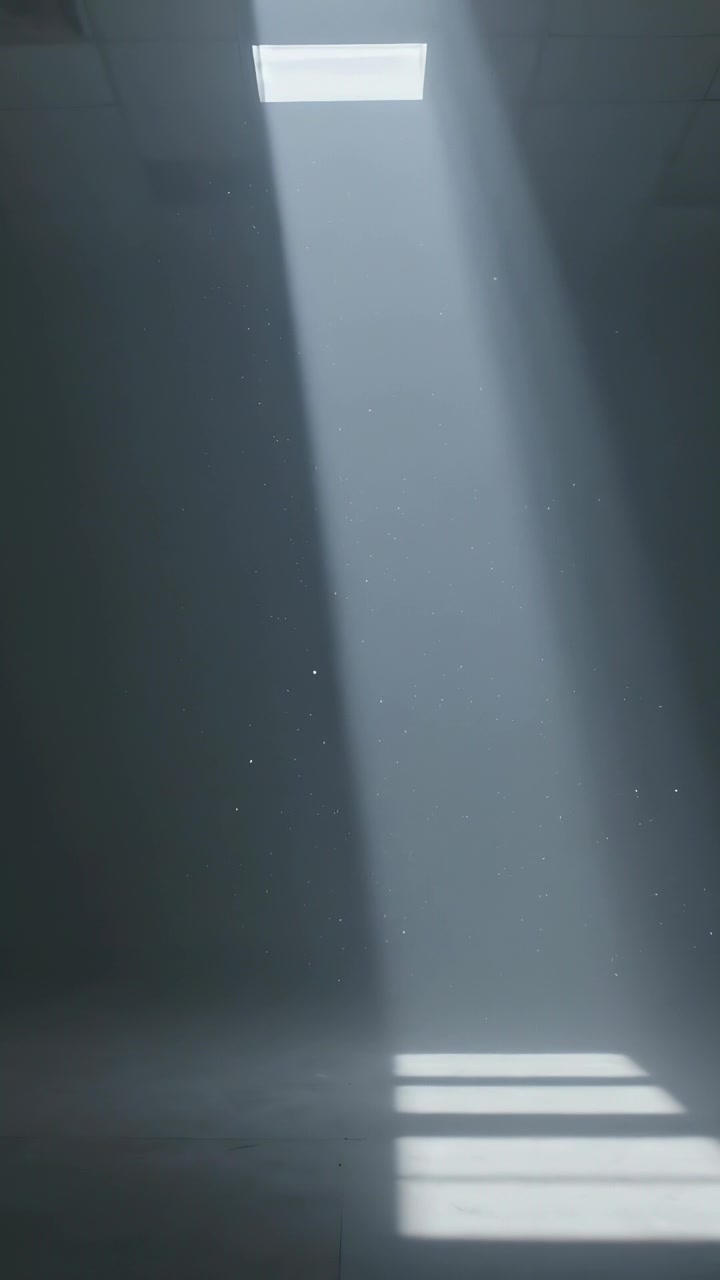 Vertical video: Shifting beam from skylight widening bands on tiled floor as sun moving with dust